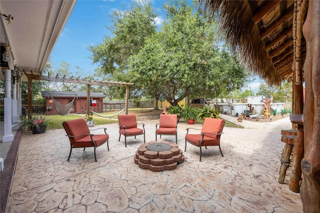 view of patio / terrace with an outdoor fire pit, a pergola, a jacuzzi, and a storage shed