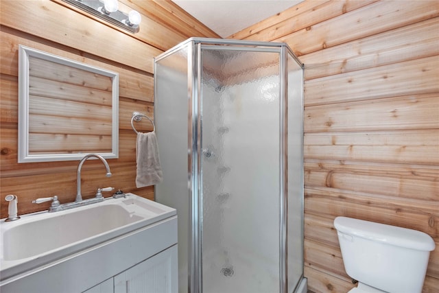 bathroom with toilet, a shower with door, vanity, and wooden walls