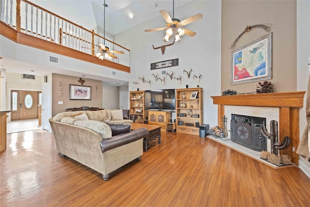 living room featuring high vaulted ceiling, light wood-type flooring, and ceiling fan