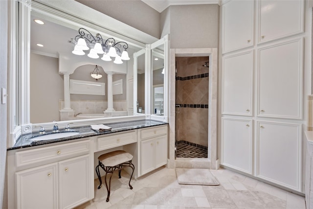 bathroom with ornamental molding, a shower with shower door, vanity, and decorative columns