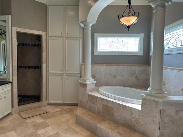 1290 County Road 145, Alvin, TX 77511 - full bathroom featuring ornate columns, a bath, a shower stall, and healthy amount of natural light