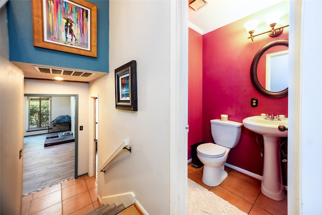 bathroom featuring toilet, ornamental molding, sink, and tile patterned flooring