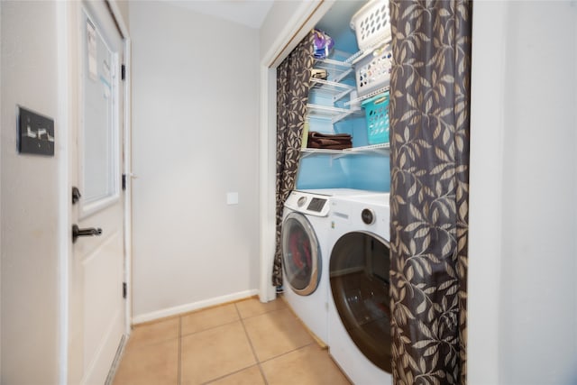 clothes washing area featuring washer and dryer and light tile patterned flooring