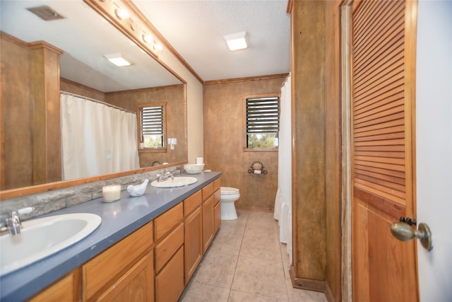 bathroom with toilet, tile patterned flooring, crown molding, vanity, and a textured ceiling