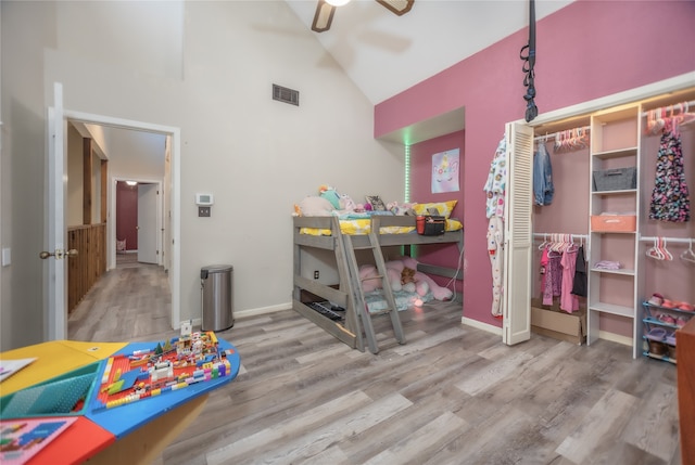 bedroom featuring ceiling fan, high vaulted ceiling, a closet, and hardwood / wood-style flooring