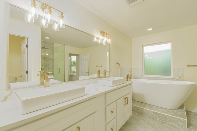 bathroom featuring vanity and shower with separate bathtub