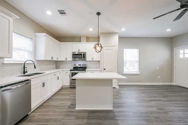 kitchen with hardwood / wood-style floors, white cabinetry, stainless steel appliances, and sink