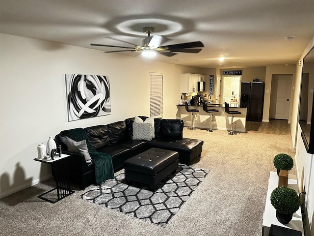 living area with baseboards, a ceiling fan, and carpet floors