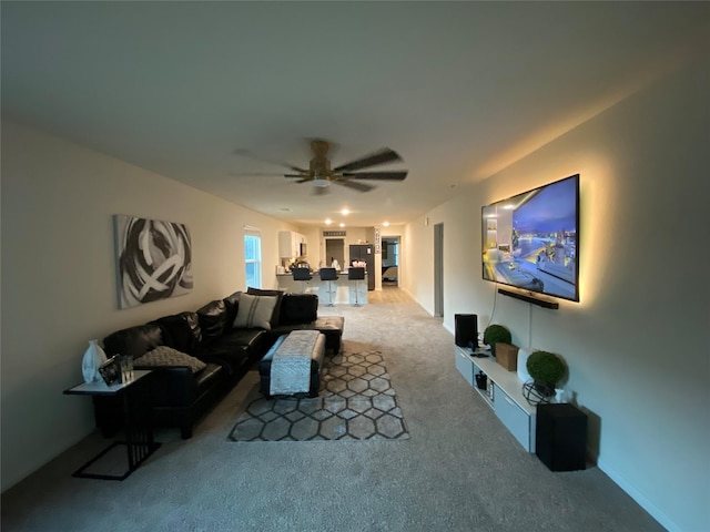 carpeted living room with ceiling fan