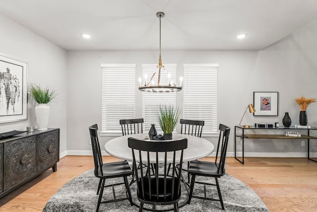 dining area featuring light hardwood / wood-style floors and a chandelier