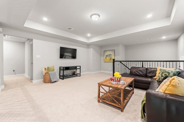 carpeted living room featuring a tray ceiling