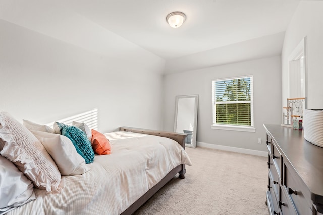 bedroom with lofted ceiling and light colored carpet