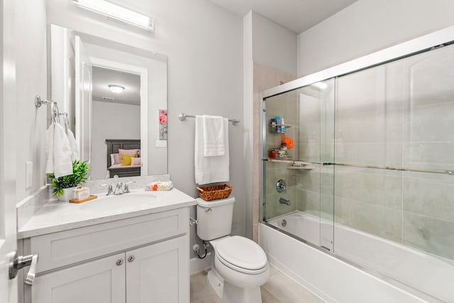 full bathroom featuring vanity, shower / bath combination with glass door, toilet, and tile patterned flooring