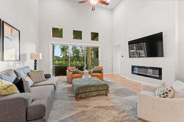 living room featuring wood-type flooring, high vaulted ceiling, and ceiling fan