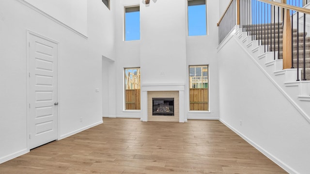 unfurnished living room with a brick fireplace and light hardwood / wood-style flooring