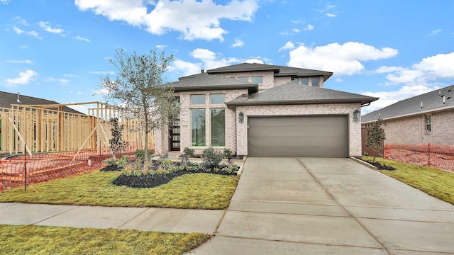 view of front of home featuring a garage and a front lawn