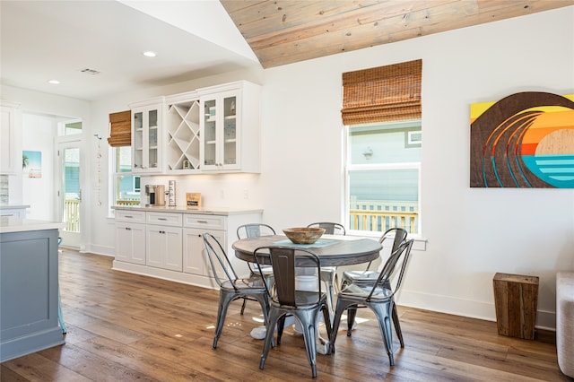 dining space featuring vaulted ceiling and dark hardwood / wood-style flooring