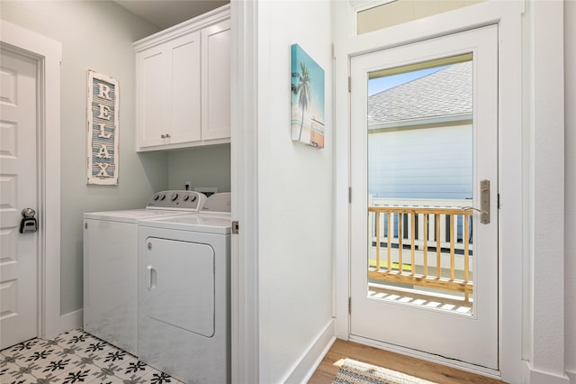 laundry room with washing machine and dryer and cabinets