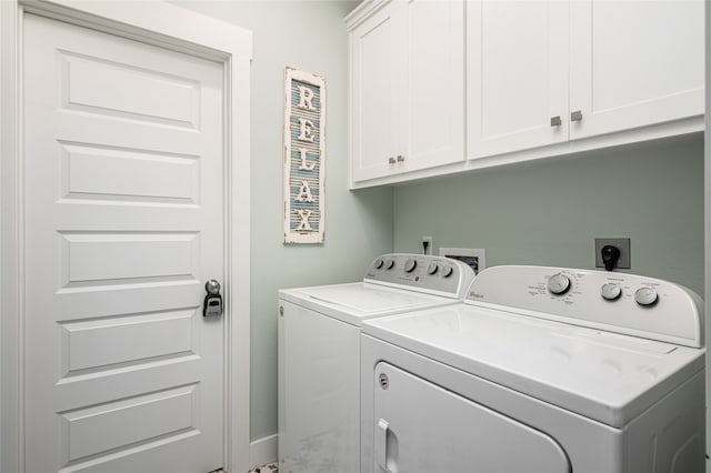 laundry room with washing machine and dryer and cabinets