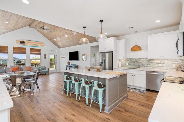 kitchen featuring appliances with stainless steel finishes, light hardwood / wood-style flooring, white cabinetry, and wooden ceiling