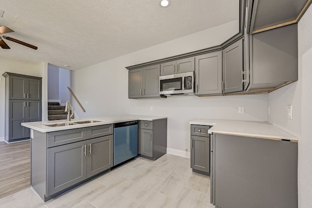 kitchen with gray cabinets, a textured ceiling, stainless steel appliances, and sink