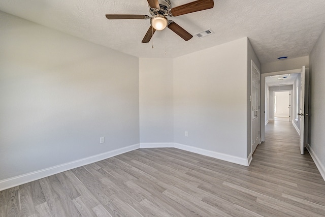 spare room with light hardwood / wood-style floors and a textured ceiling