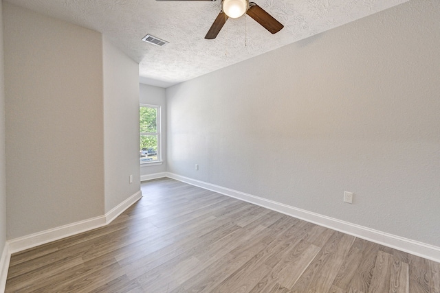 spare room with ceiling fan, hardwood / wood-style flooring, and a textured ceiling