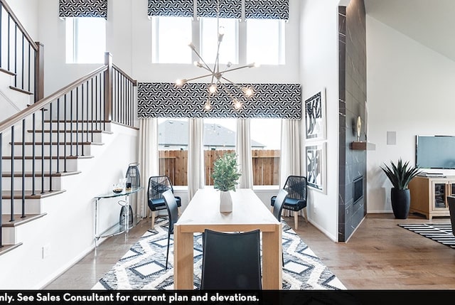 dining area with a chandelier, a high ceiling, and light wood-type flooring