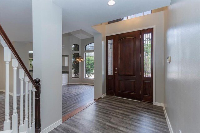 foyer entrance with a chandelier and dark wood-type flooring