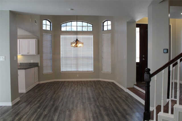 unfurnished dining area with a chandelier and dark wood-type flooring