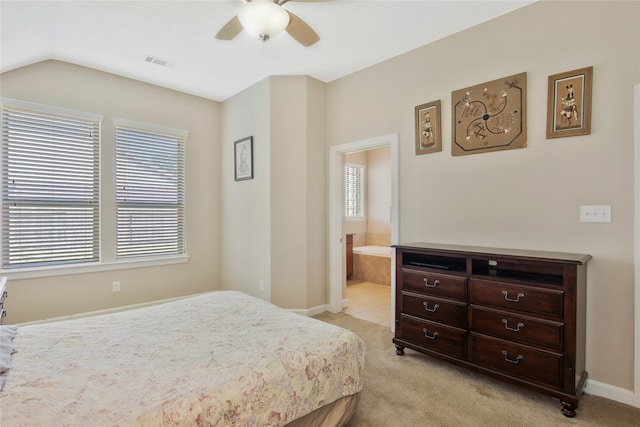 bedroom with light carpet, multiple windows, connected bathroom, and ceiling fan