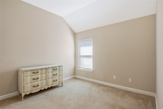 carpeted spare room featuring lofted ceiling