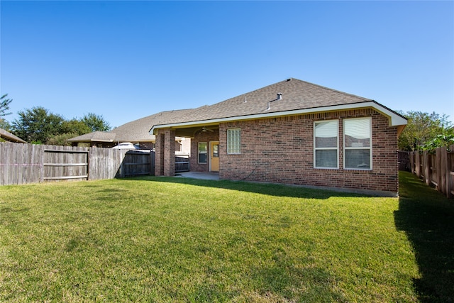 rear view of property featuring a yard