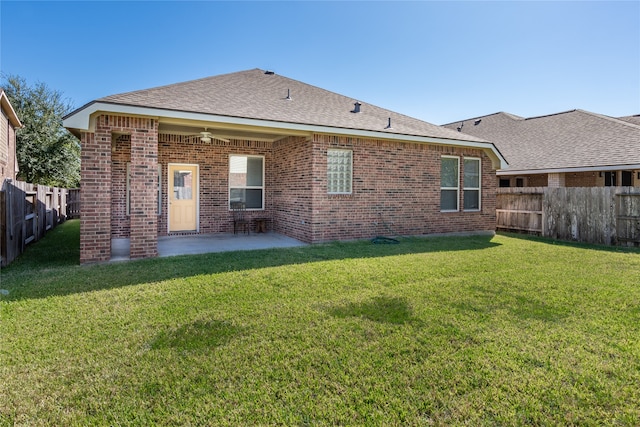 rear view of property featuring a yard and a patio area