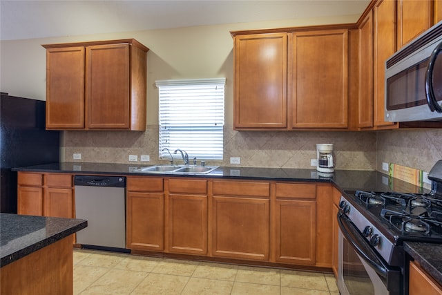 kitchen with backsplash, dark stone countertops, sink, black appliances, and light tile patterned flooring