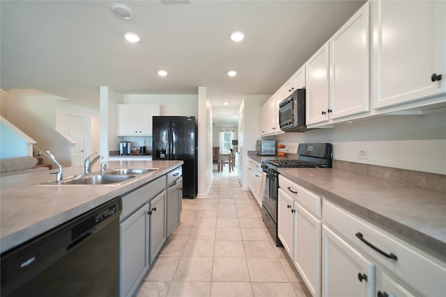 kitchen featuring light tile patterned floors, black appliances, sink, and white cabinets