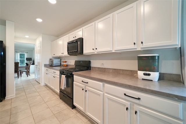 kitchen with black appliances, white cabinetry, and light tile patterned flooring