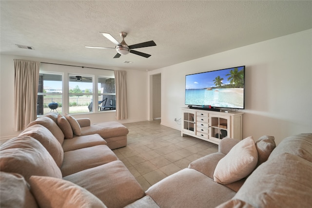 tiled living room featuring ceiling fan and a textured ceiling