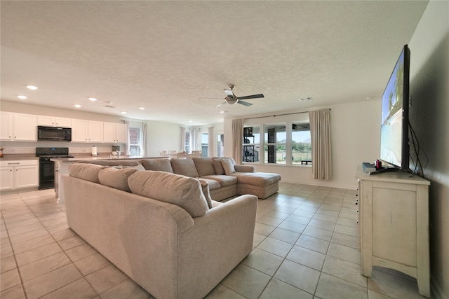 living room with light tile patterned flooring, a textured ceiling, and ceiling fan