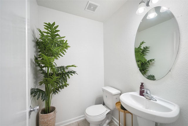 bathroom featuring sink, toilet, and tile patterned flooring