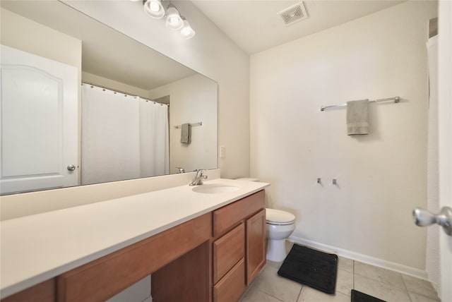 bathroom with vanity, toilet, and tile patterned flooring