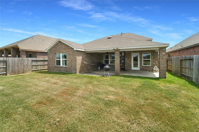 back of house with a patio and a lawn