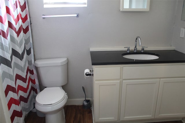 bathroom featuring walk in shower, hardwood / wood-style flooring, vanity, and toilet