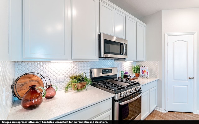 kitchen with light hardwood / wood-style floors, white cabinets, stainless steel appliances, and backsplash