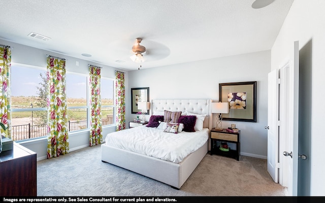 bedroom with ceiling fan, a textured ceiling, and light colored carpet