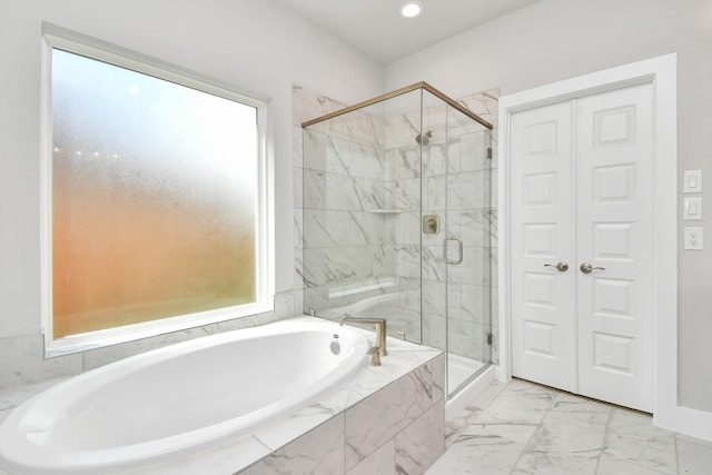 bathroom with a healthy amount of sunlight, a marble finish shower, and a bath