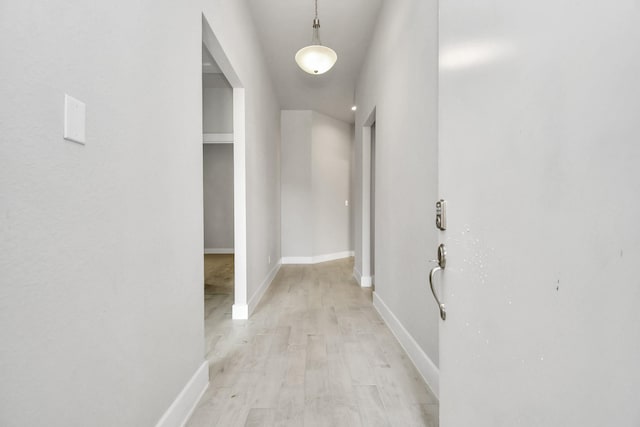 hallway with baseboards and light wood-type flooring