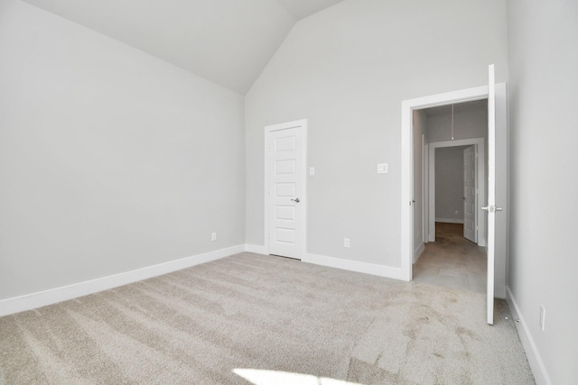 unfurnished bedroom with high vaulted ceiling, carpet floors, and baseboards