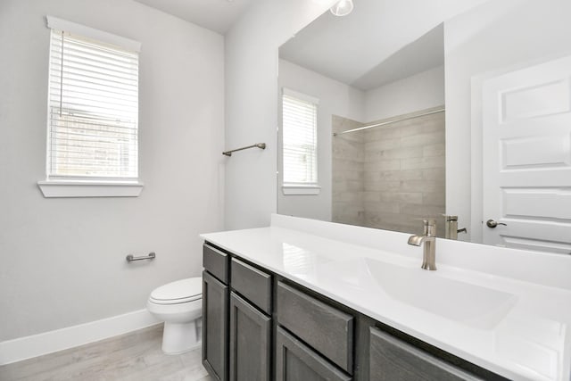 full bath with vanity, toilet, baseboards, walk in shower, and wood finished floors