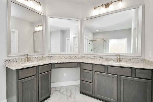 bathroom featuring a stall shower, marble finish floor, double vanity, and a sink